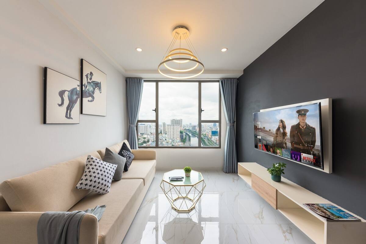 Una sala de estar moderna con sofá, mesa de centro y televisor.