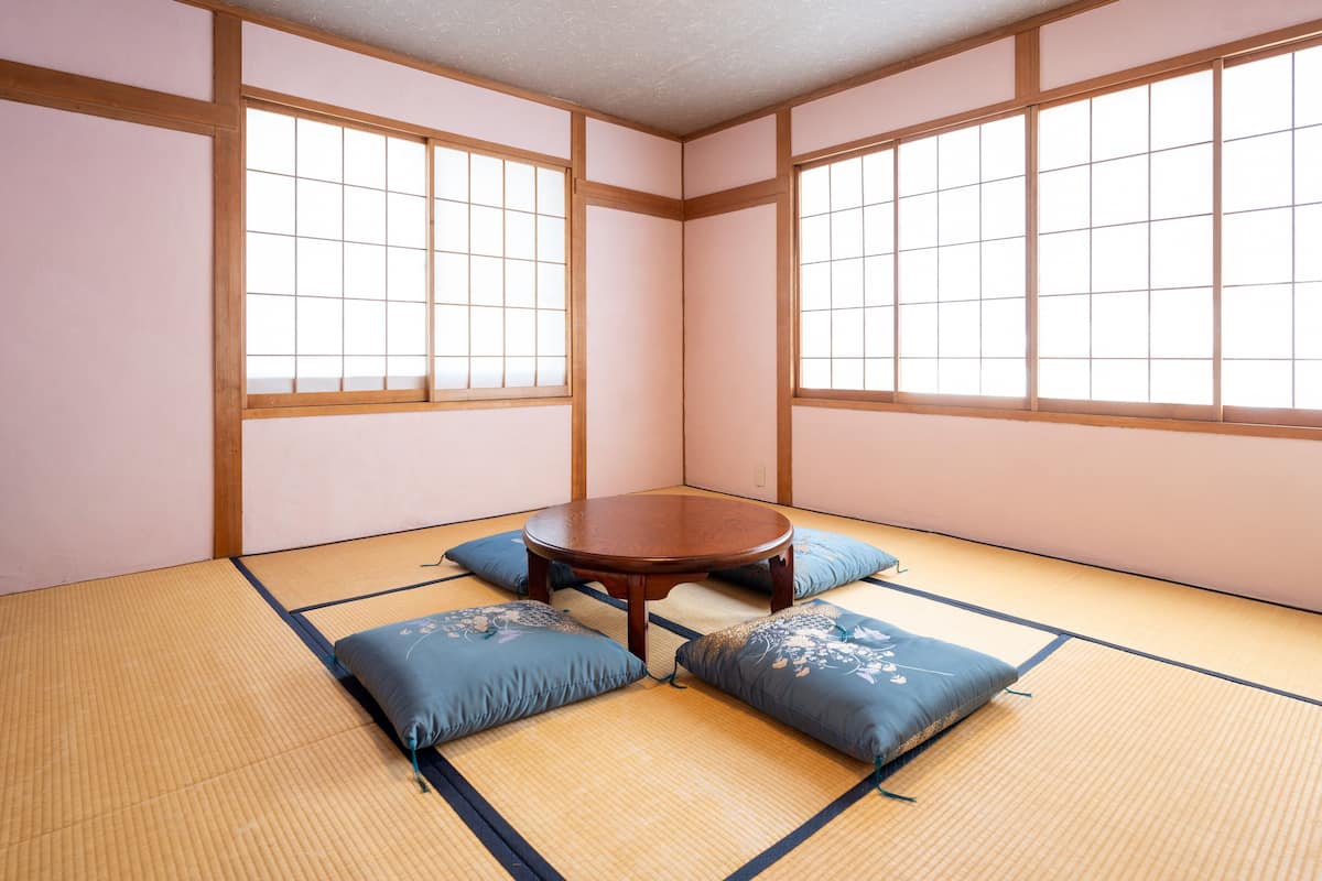 A tatami mat room with a wooden table and cushions.