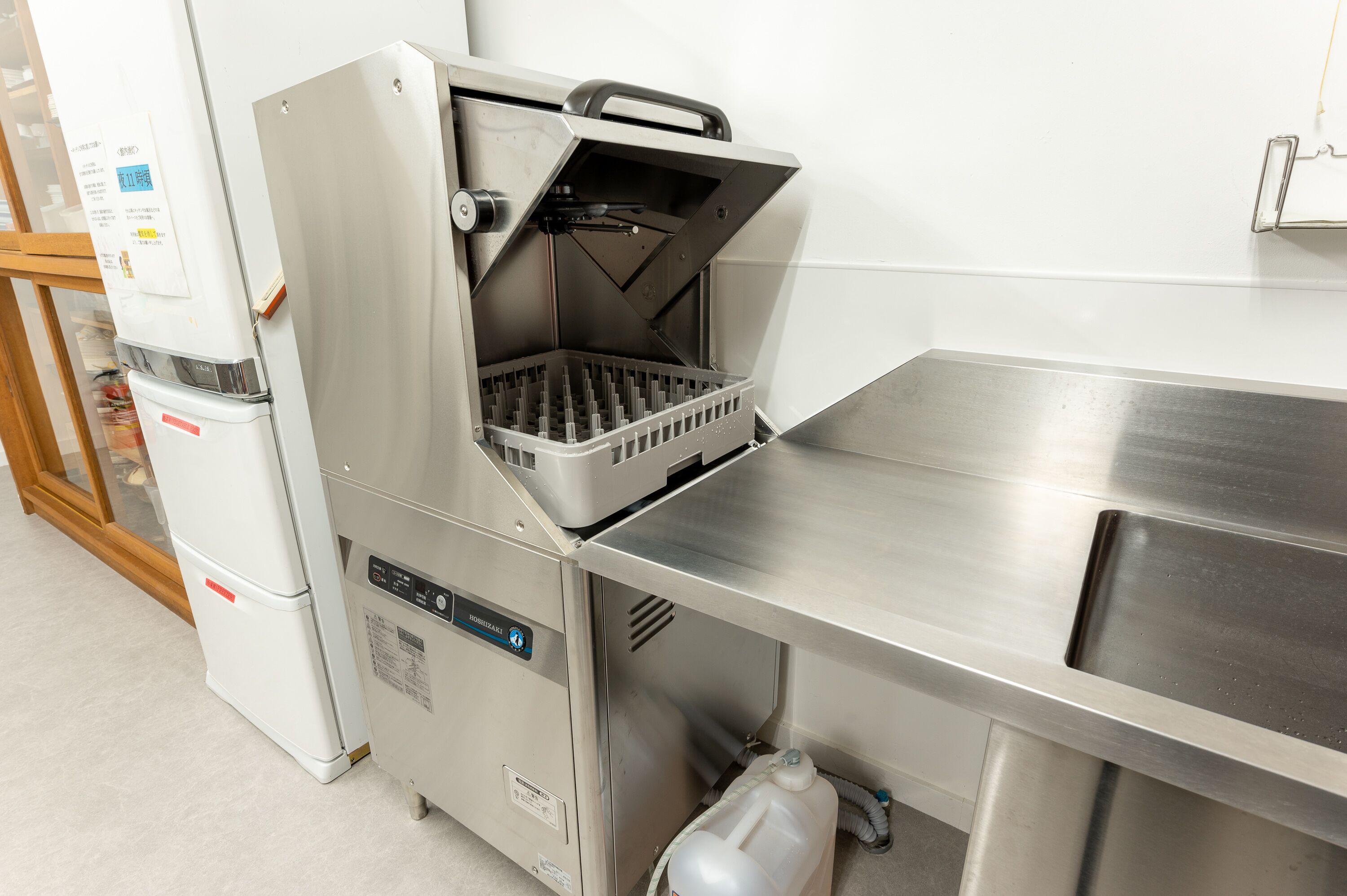 Una cucina professionale dotata di elettrodomestici in acciaio inossidabile, tra cui una friggitrice e un frigorifero.
