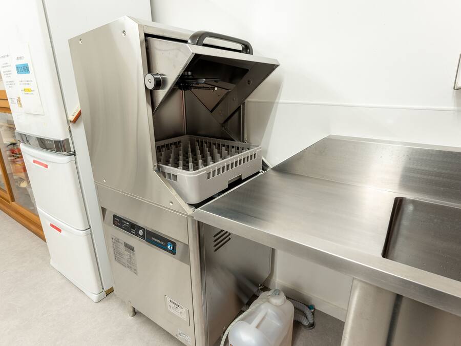 Una cucina professionale dotata di elettrodomestici in acciaio inossidabile, tra cui una friggitrice e un frigorifero.