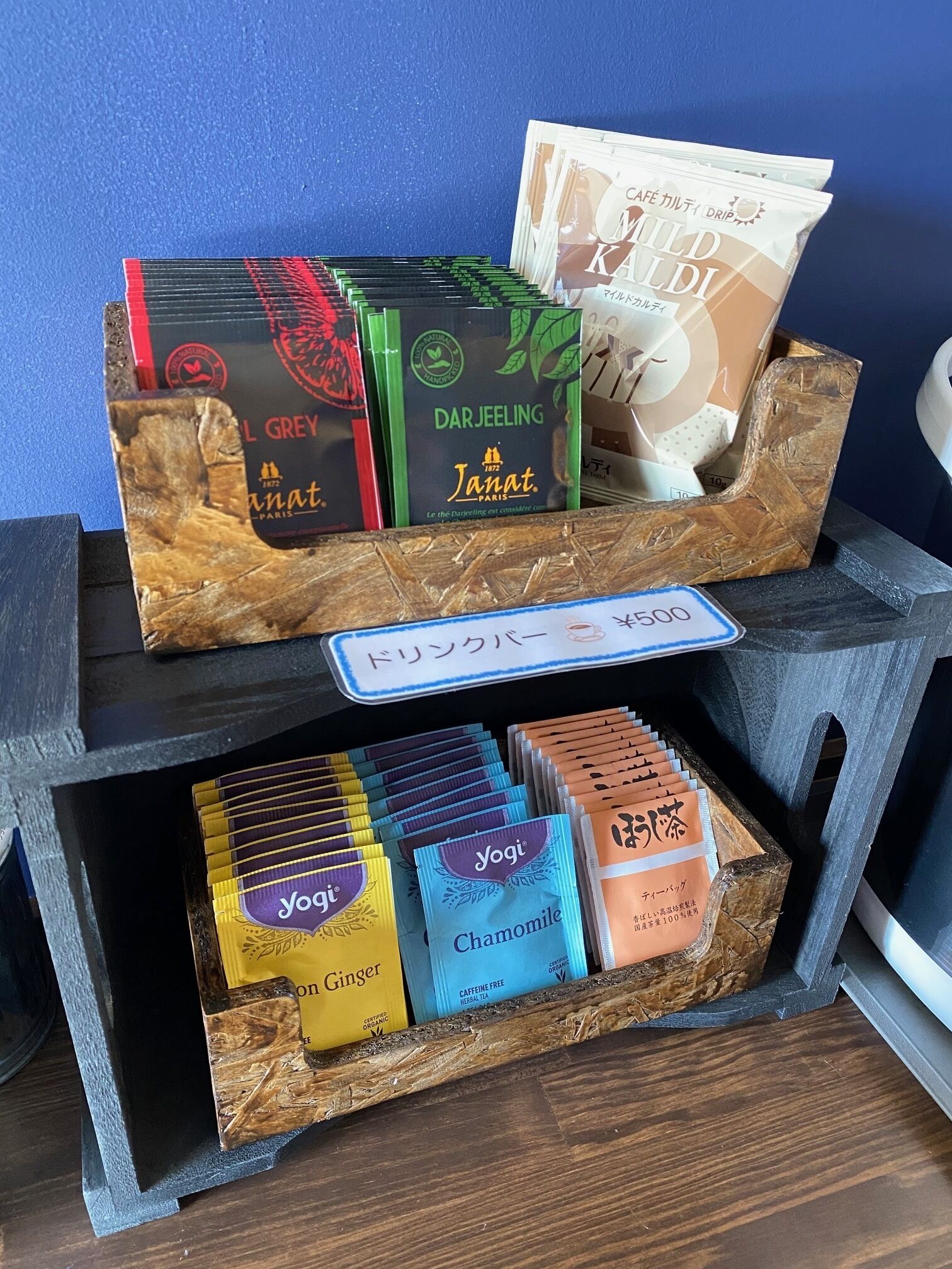 Una exhibición de productos de té, incluyendo Darjeeling y Janat, junto con diversas infusiones de hierbas como manzanilla y jengibre.