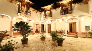 A courtyard with potted plants, a wooden staircase, and a balcony with railings. - Hotel Casa de Familia de San Cristobal (San Cristóbal de las Casas)
