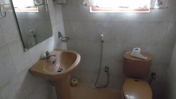Un baño con lavamanos, inodoro y ducha.