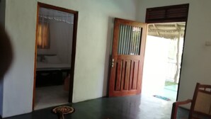 Una habitación con puerta de madera, una mesa y una silla.