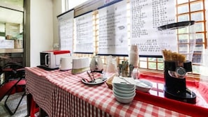 A dining area with a red and white checkered tablecloth, a menu board, and a coffee machine. - Namwon Hotel (Namwon)