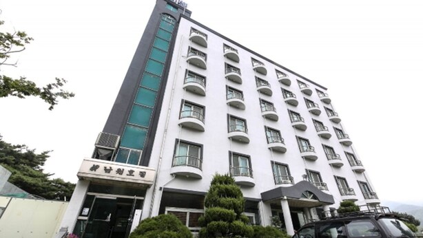 A multi-story hotel with a white facade, balconies on each floor, and a sign in a foreign language at the entrance. - Namwon Hotel (Namwon)