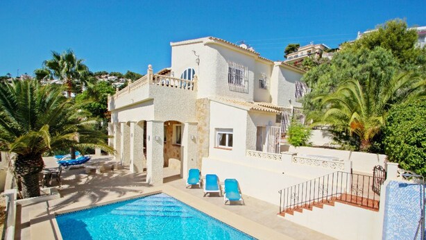 A two-story building with a swimming pool, lounge chairs, and palm trees. - Casa del Campo - sea view villa with private pool in Moraira (Moraira)