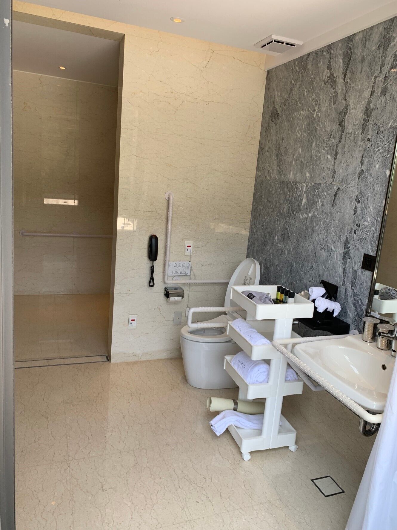 A modern bathroom with a toilet, sink, and shower area.