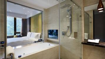 A modern bathroom with a large mirror, a bathtub, and a shower.