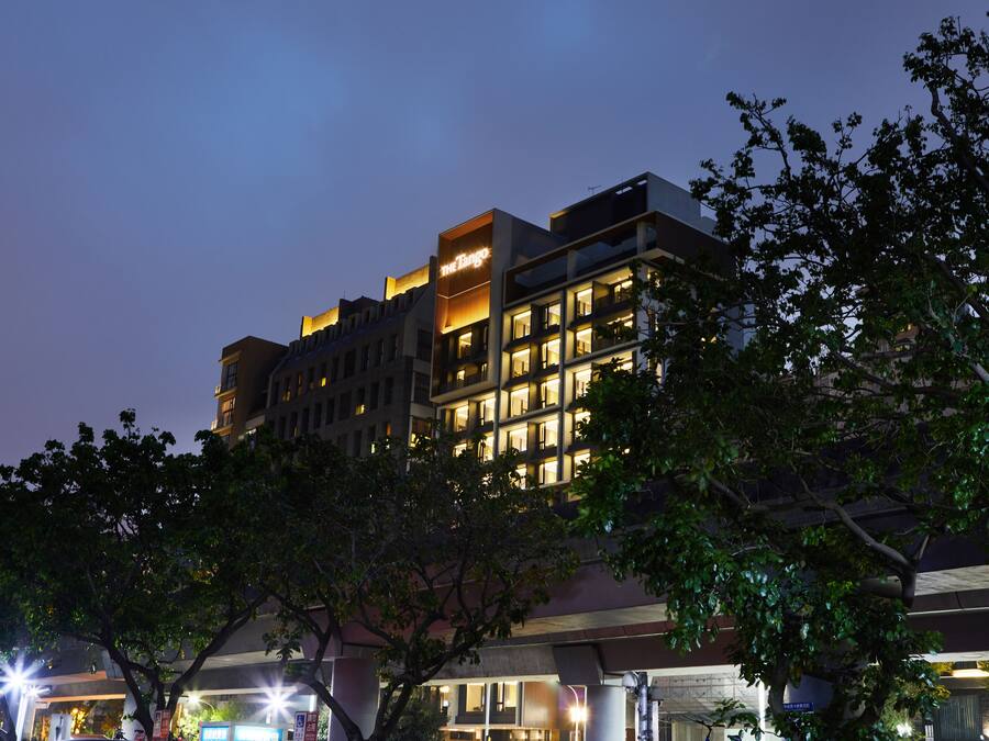 A multi-story hotel with illuminated signage and a modern architectural design.