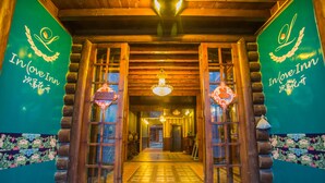 A wooden entrance with a chandelier, a sign reading "In Love Inn," and traditional Chinese decorations. - Lugu Lake Love Inn (Lijiang)