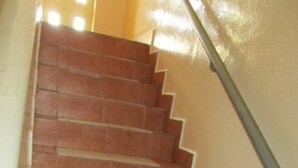 Eine Treppe mit abwechselnden roten und weißen Fliesen, die zu einer Zwischenebene führt.