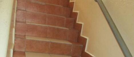 A staircase with alternating red and white tiles leading up to a landing.