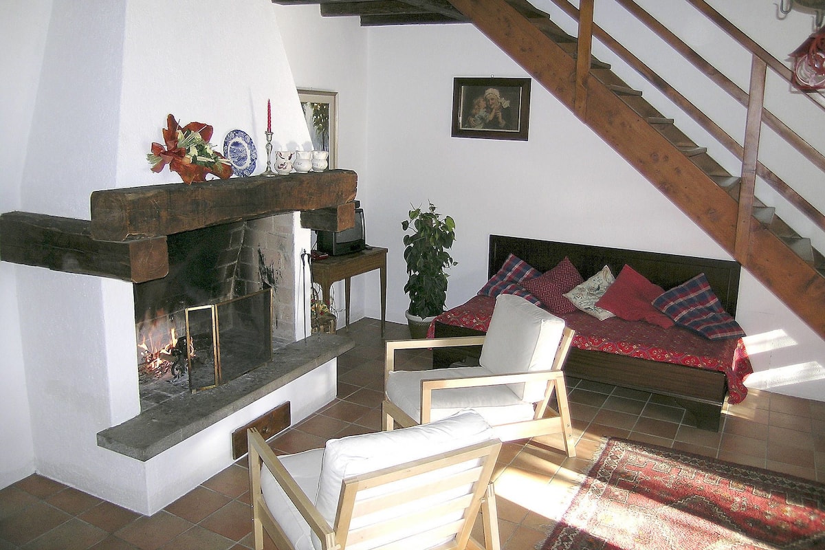 A cozy living room with a fireplace, a sofa, and a chair.