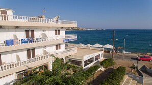 Et hotel med flere balkoner, en cafébar og havudsigt.