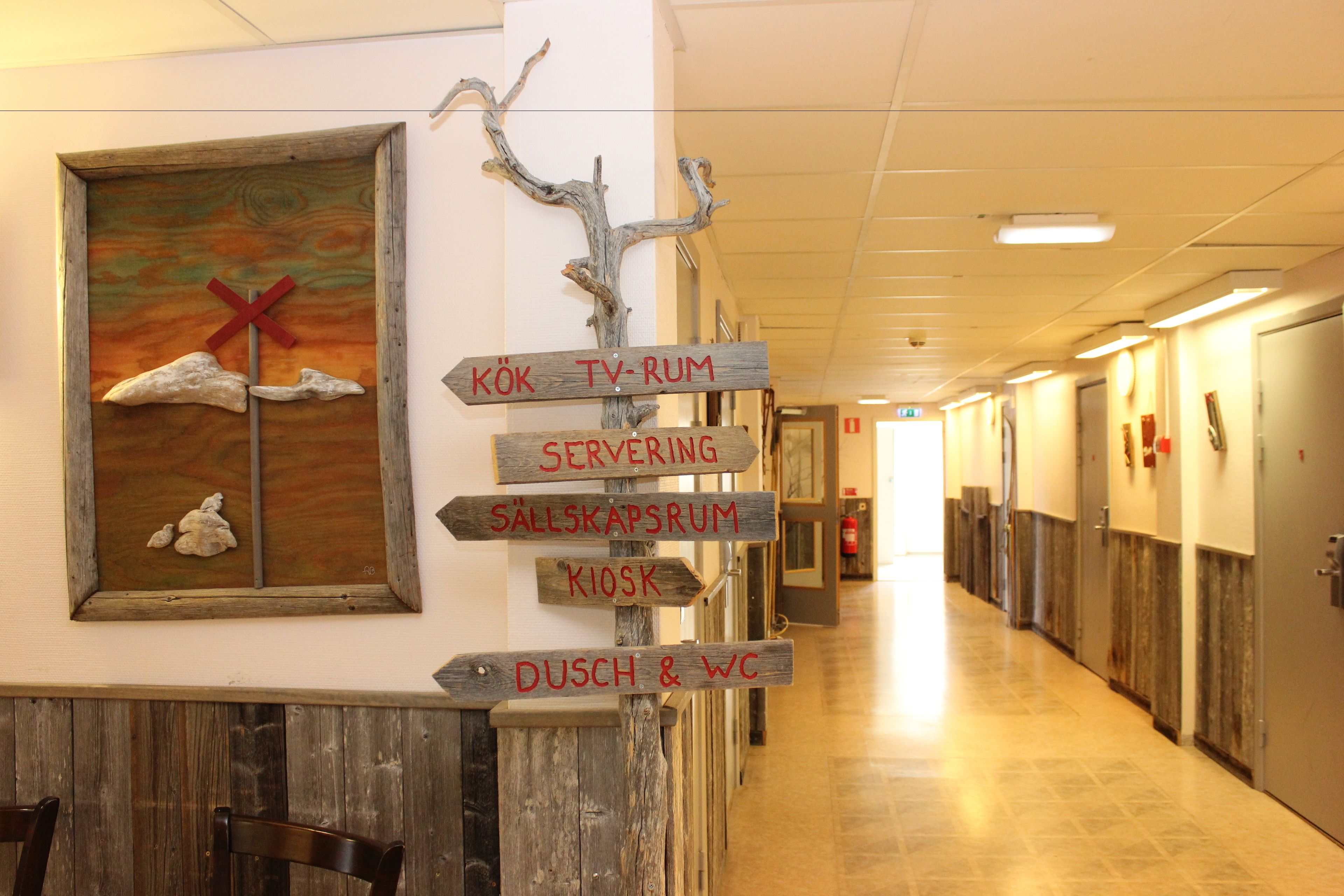 A hotel corridor with directional signs pointing to various amenities such as TV, rum, serving, and restrooms.