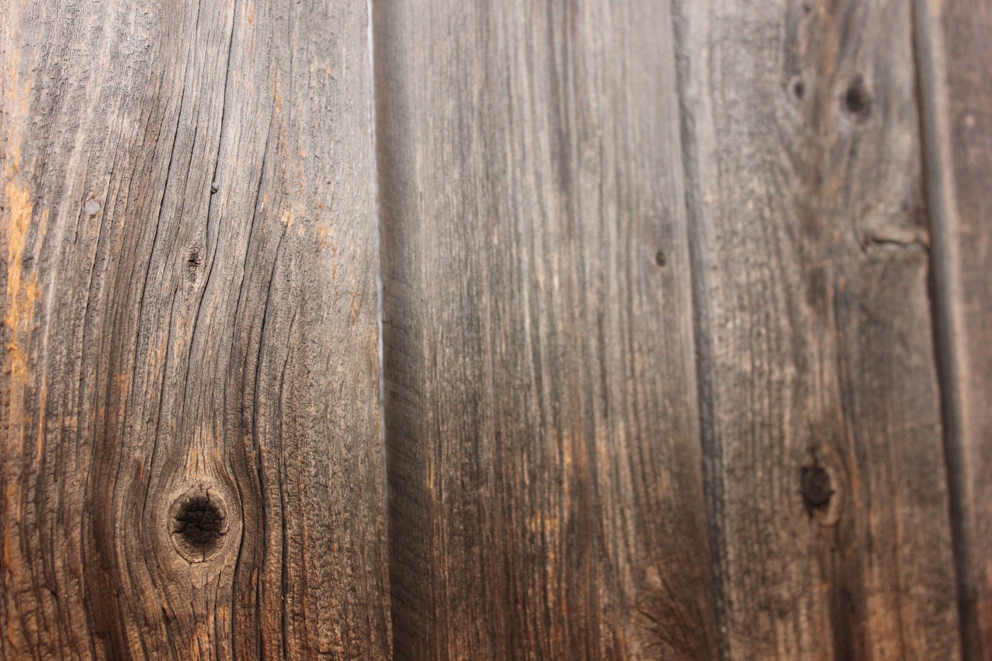 Primer plano de una superficie de madera con veta y nudos bien visibles.