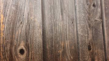 Primer plano de una superficie de madera con veta y nudos bien visibles.