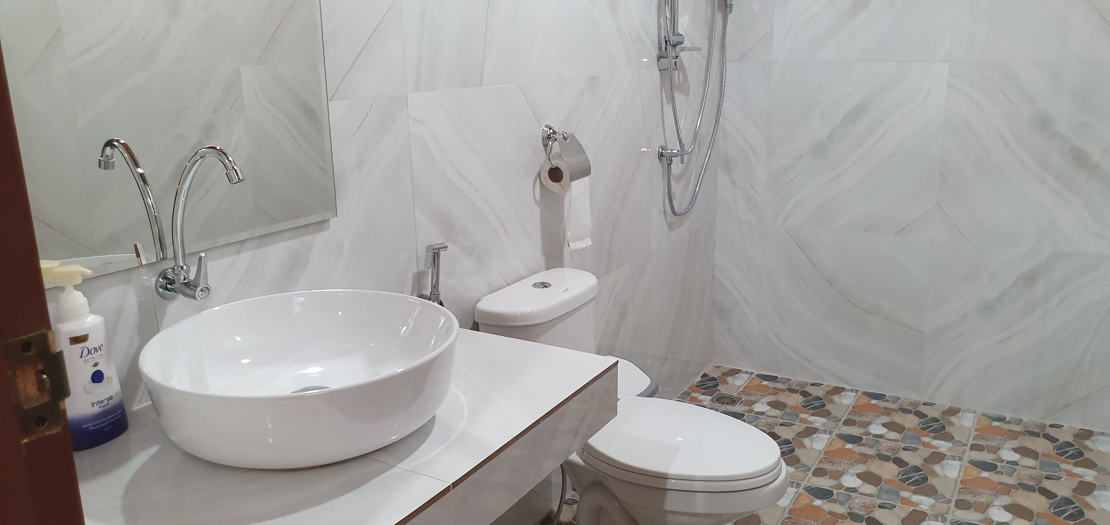 A bathroom with a large white sink, a toilet, and a shower.