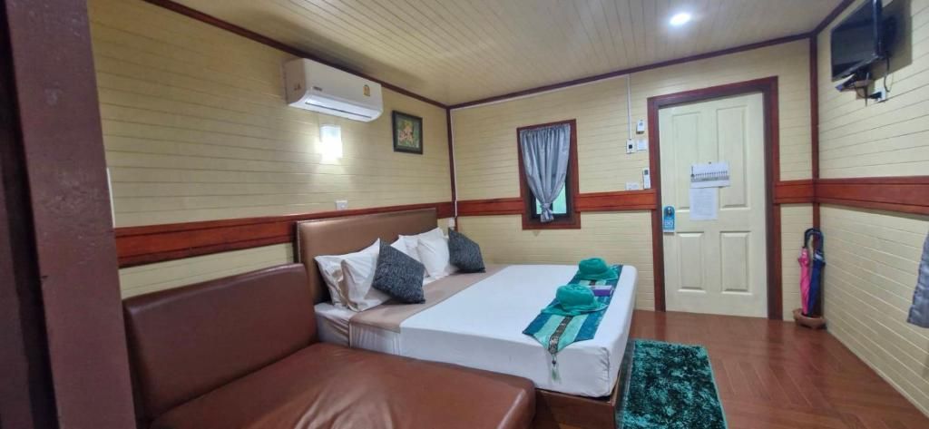 A hotel room with a bed, a seating area, a television, and a door.