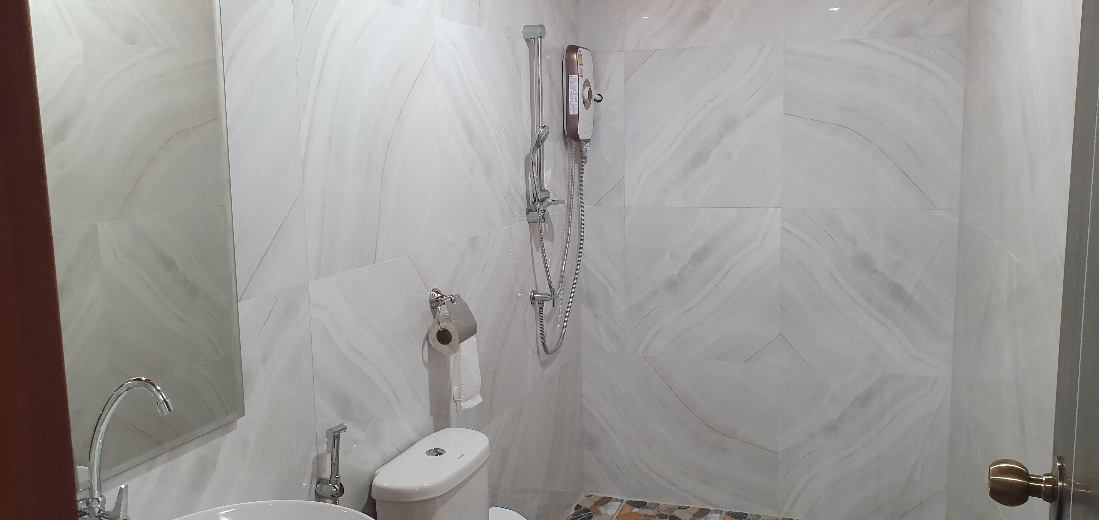 Un baño con inodoro, lavamanos y ducha.