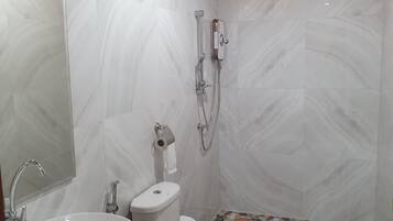 Un baño con inodoro, lavamanos y ducha.
