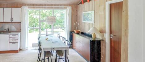Una cocina amplia con mesa y sillas, y vista a zonas verdes.
