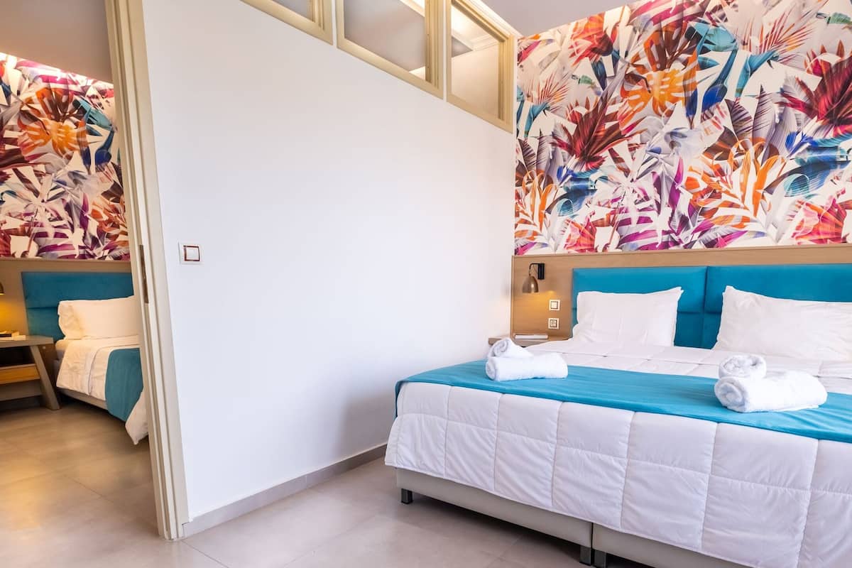 Habitación cuádruple familiar, vista al jardín | Minibar, caja de seguridad en la habitación y escritorio