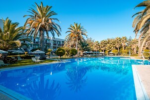 Una piscina al aire libre, sombrillas, tumbonas