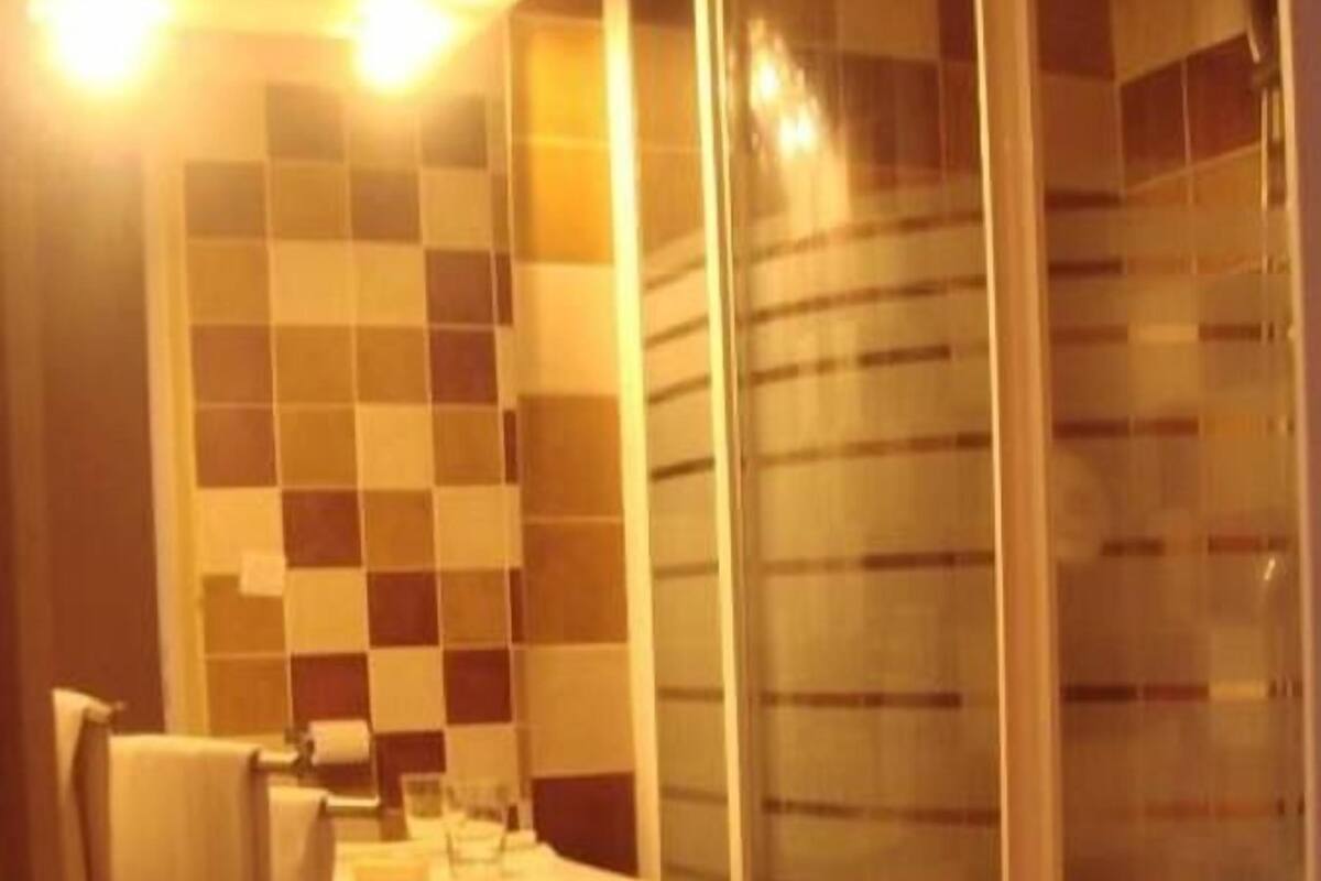 A bathroom with a shower enclosure, a sink, and a mirror.