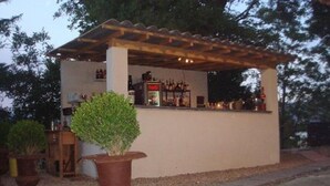 An outdoor bar area with a pergola, a potted plant, and a counter with bottles. - Hotel La Maillane (Marseille)