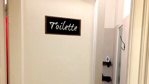 A white door with a sign reading "Toilette" and a door handle.