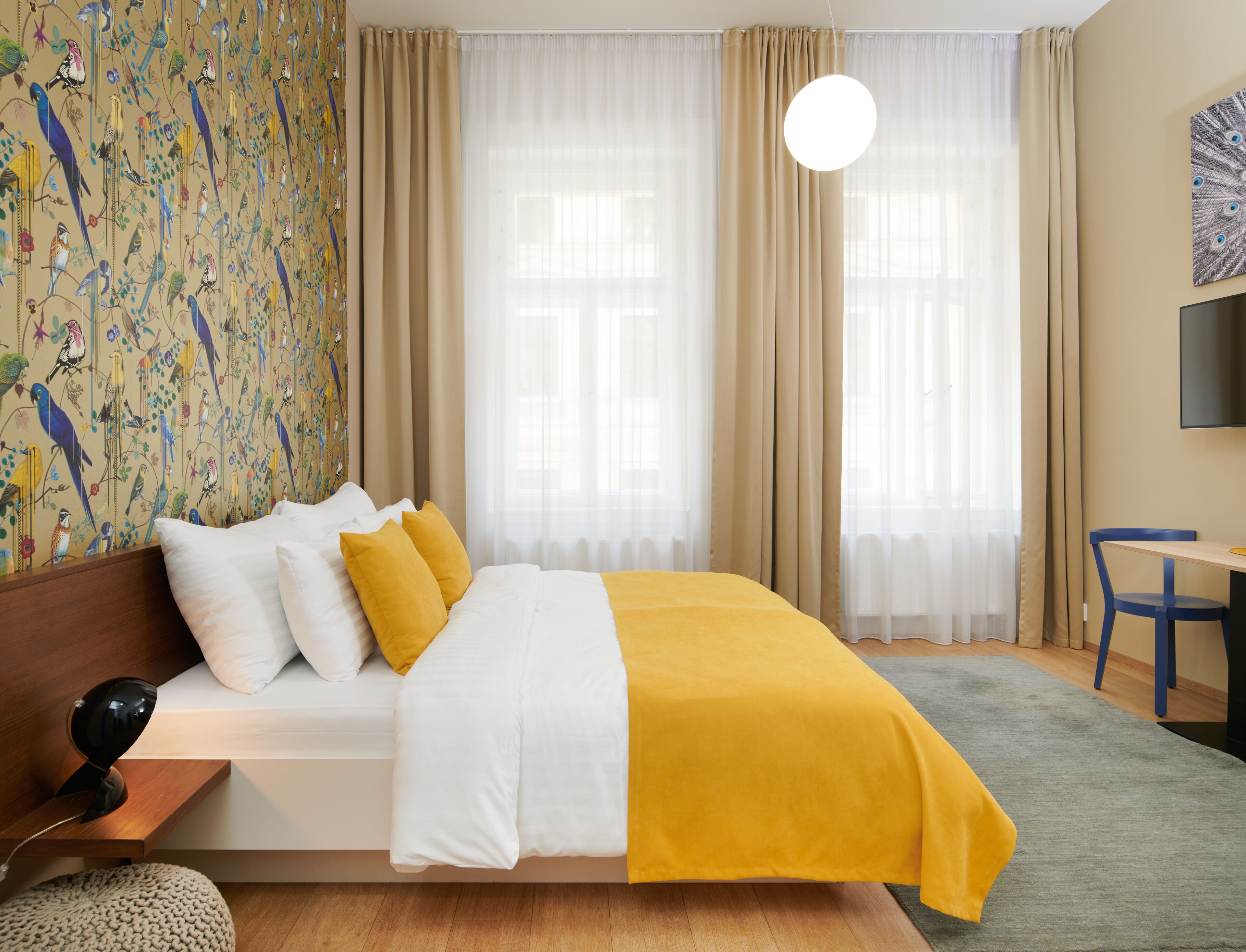 A hotel room with a bed, a desk, and a television.