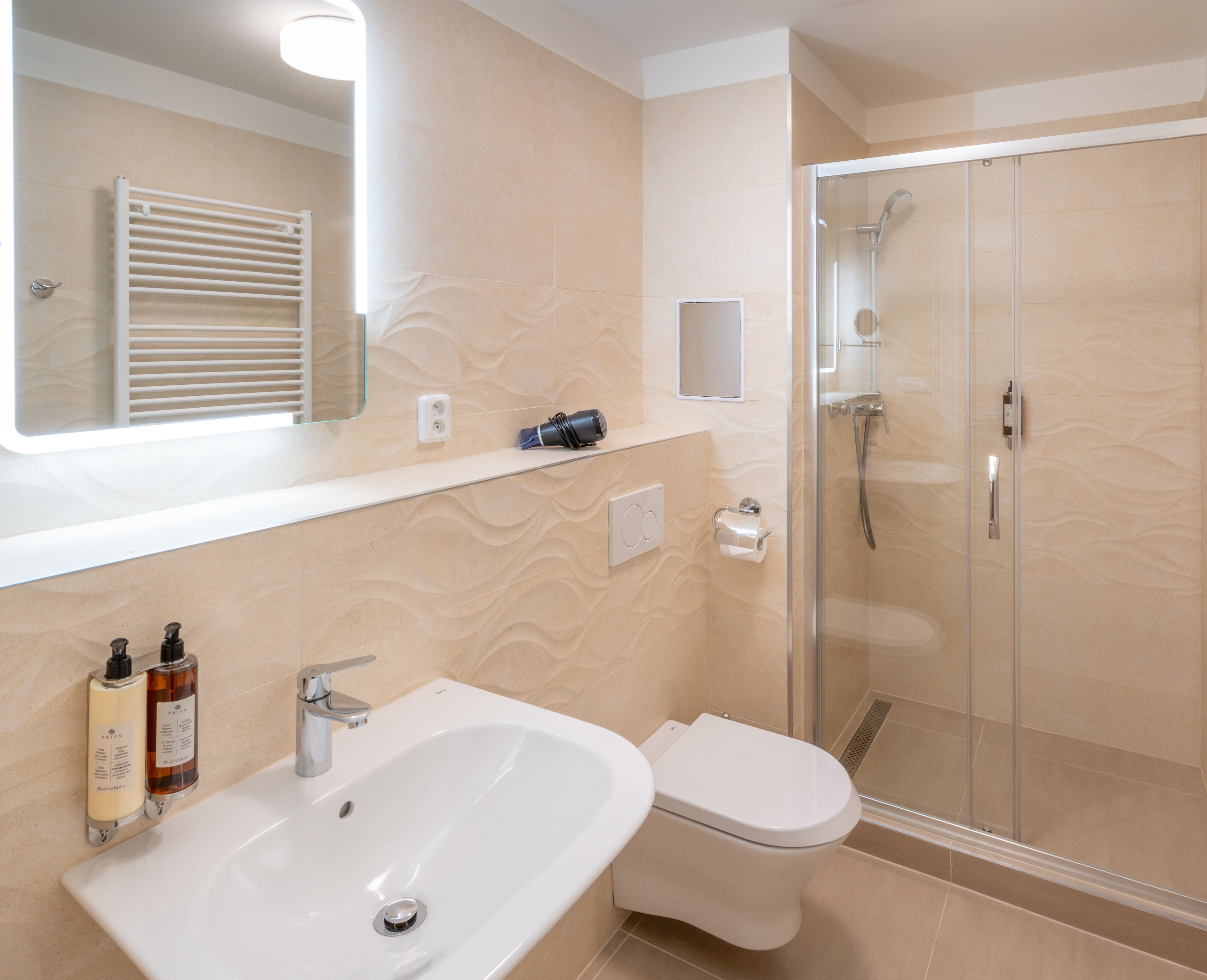 A bathroom with a sink, toilet, and glass-enclosed shower.