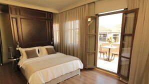 A hotel room with a large bed, a bedside table, a lamp, and a view of the outside patio. - Ferman Pera (Istanbul)