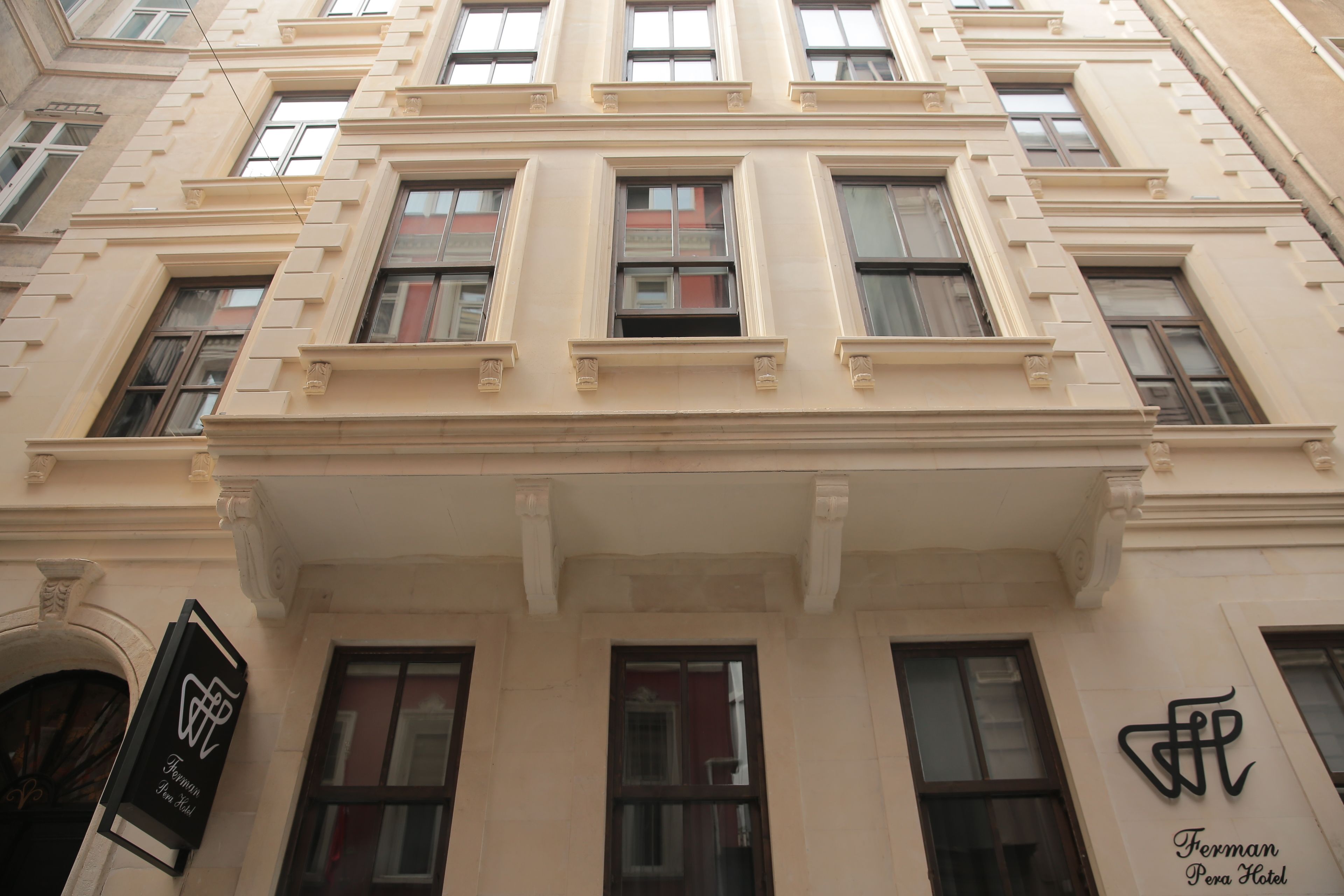 La façade d’un immeuble ornée de nombreuses fenêtres et d’une enseigne indiquant l’hôtel Ferman Pena.