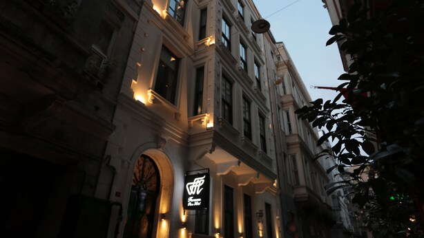 A historic building with classical architecture, featuring arched doorways and multiple windows. - Ferman Pera (Istanbul)