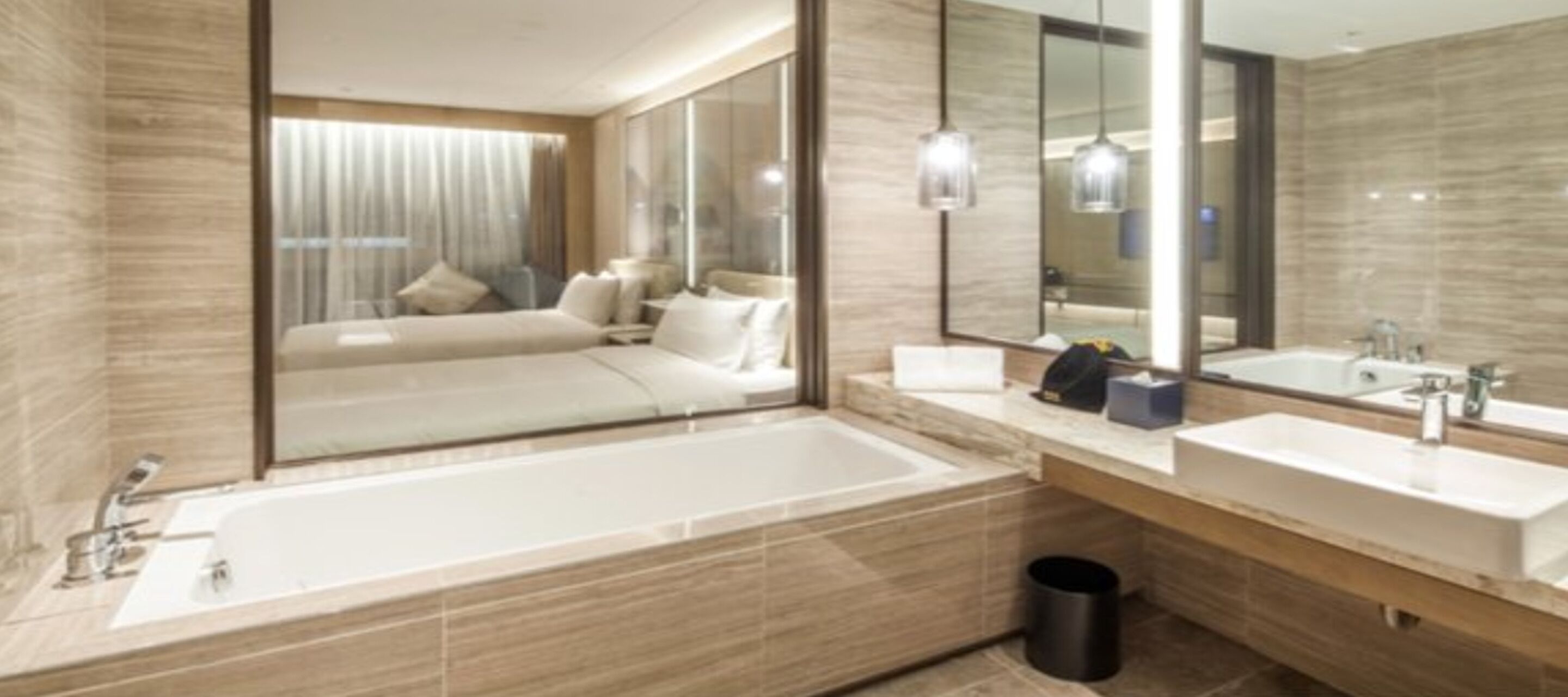 A modern bathroom with a large bathtub, two sinks, and a mirror.