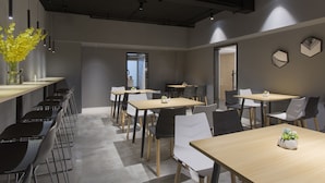 Une salle de conférence moderne, dotée de longues tables et de chaises, d’une grande fenêtre et d’une plante posée sur l’une des tables.