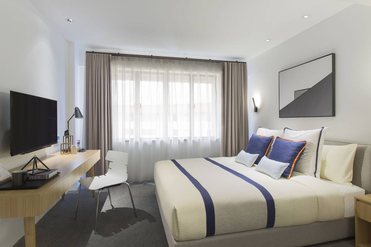 Escritorio, cortinas blackout y tabla de planchar con plancha 