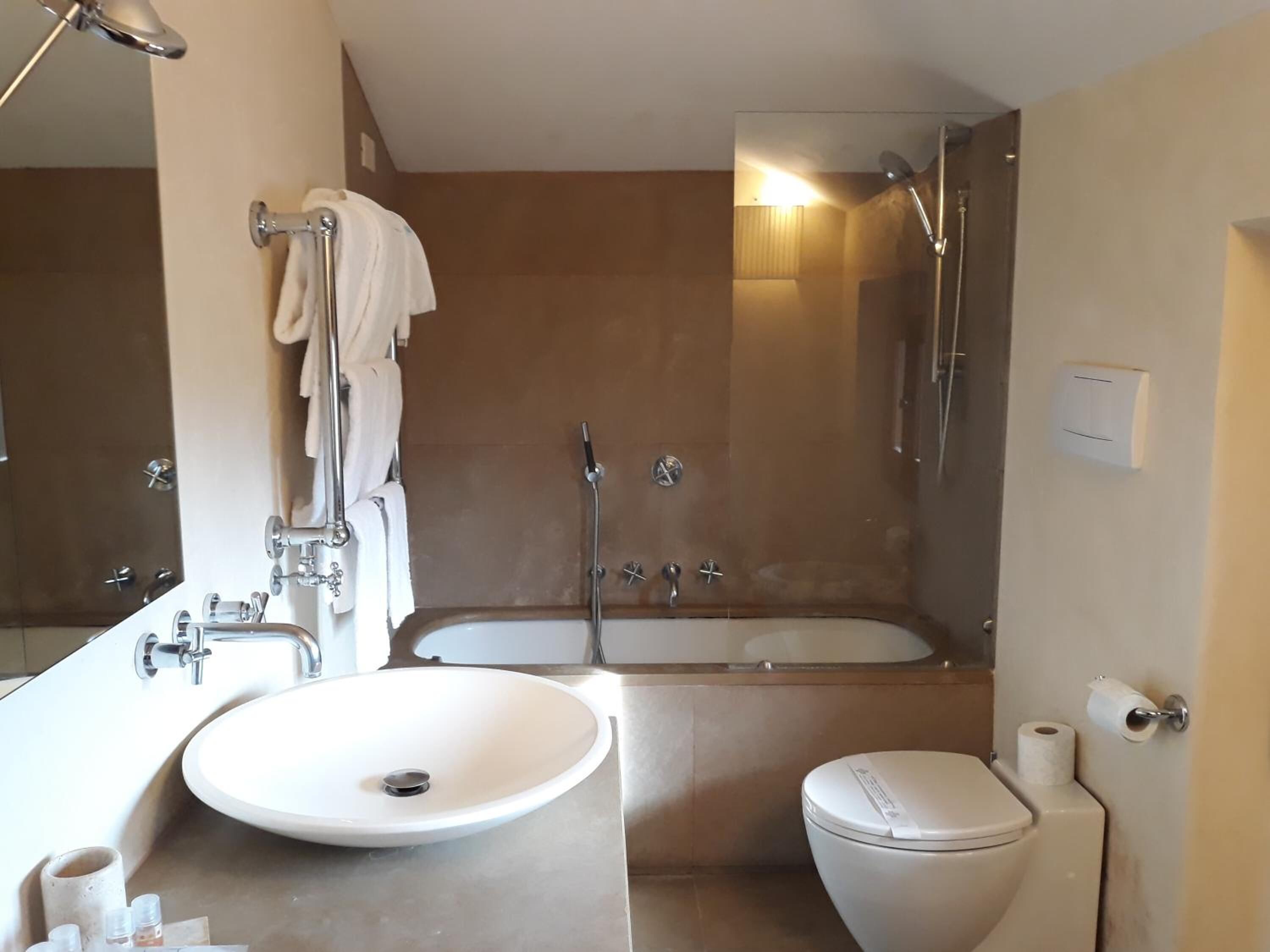 A modern bathroom with a sink, toilet, and bathtub.