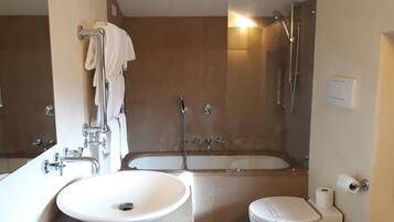 A modern bathroom with a sink, toilet, and bathtub.