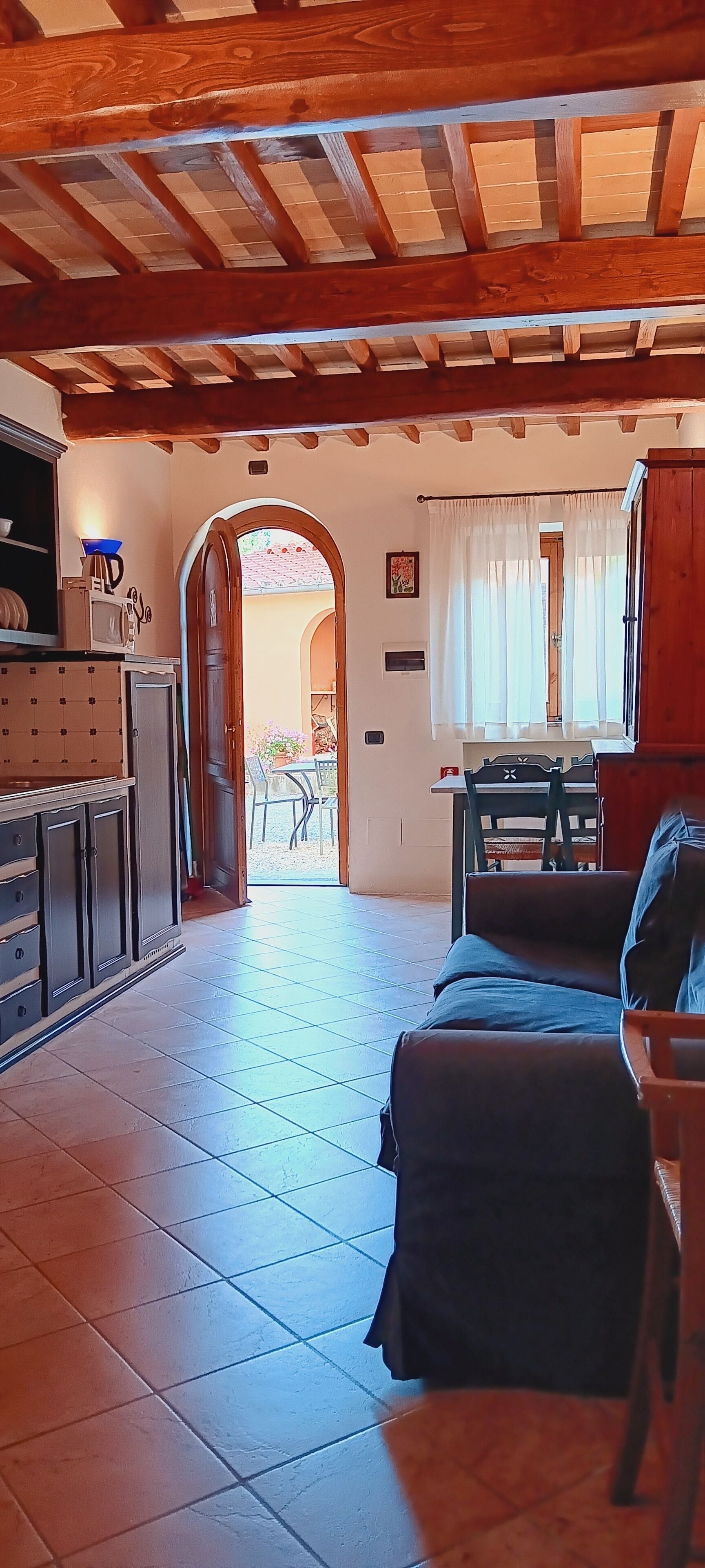 A cozy room with a wooden ceiling, a bed, a table, and a chair.