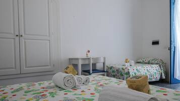 Enjoy a comfortable stay with a large wardrobe, table, and chair, plus a bed with a floral bedspread.