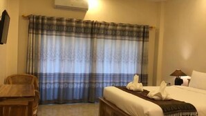 A hotel room with a wooden bed, a desk, and a chair.