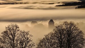 A landscape with buildings partially obscured by fog.