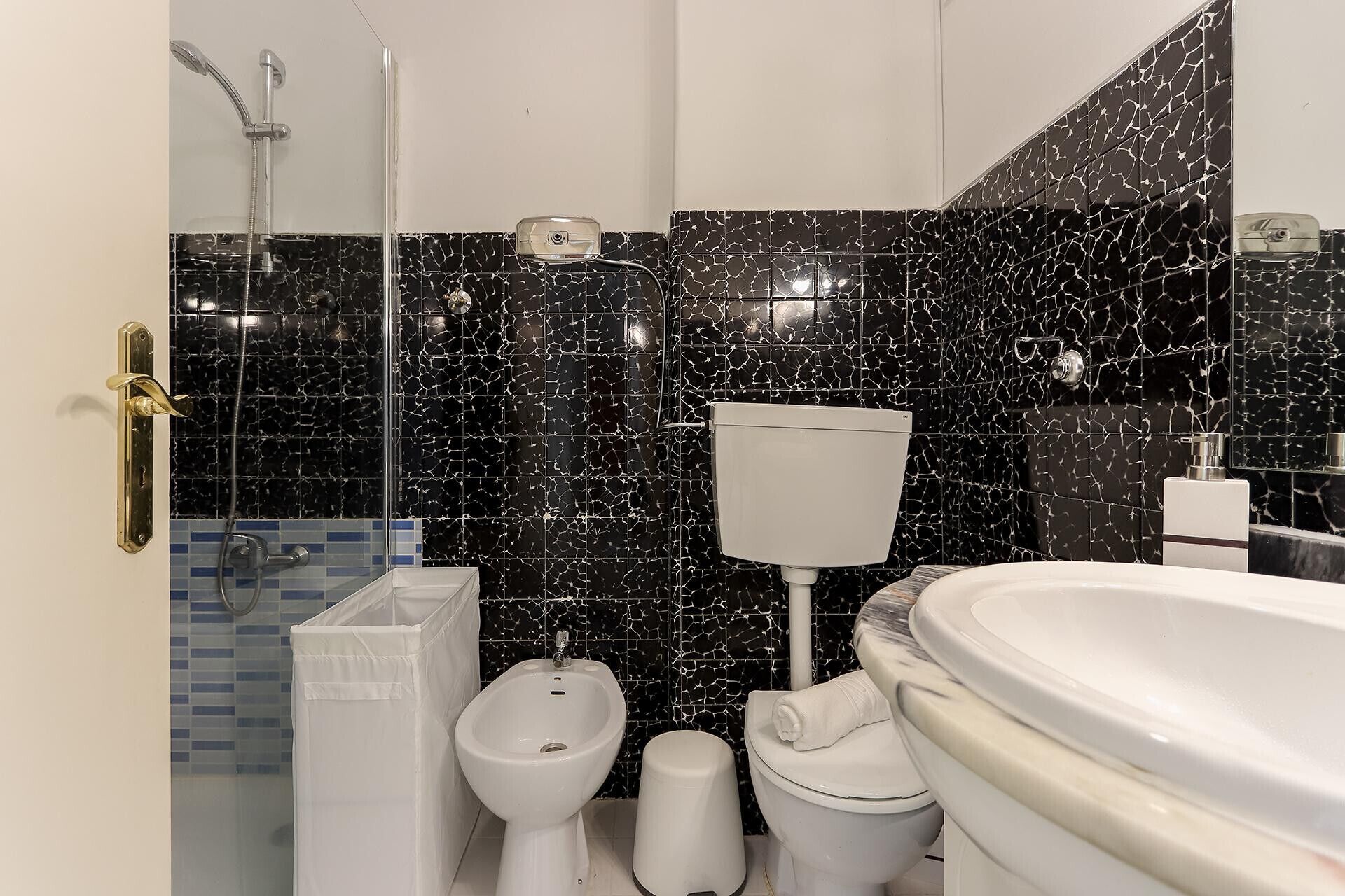 A bathroom with a toilet, bidet, and bathtub.