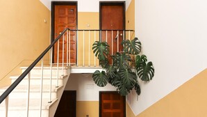 A multi-level interior with a staircase, wooden doors, and a potted plant. - Principe Real Balcony by Homing (Lisbon)