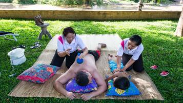 Guests can enjoy a workout or yoga session on the lush grass, surrounded by a serene water feature and a brick wall.