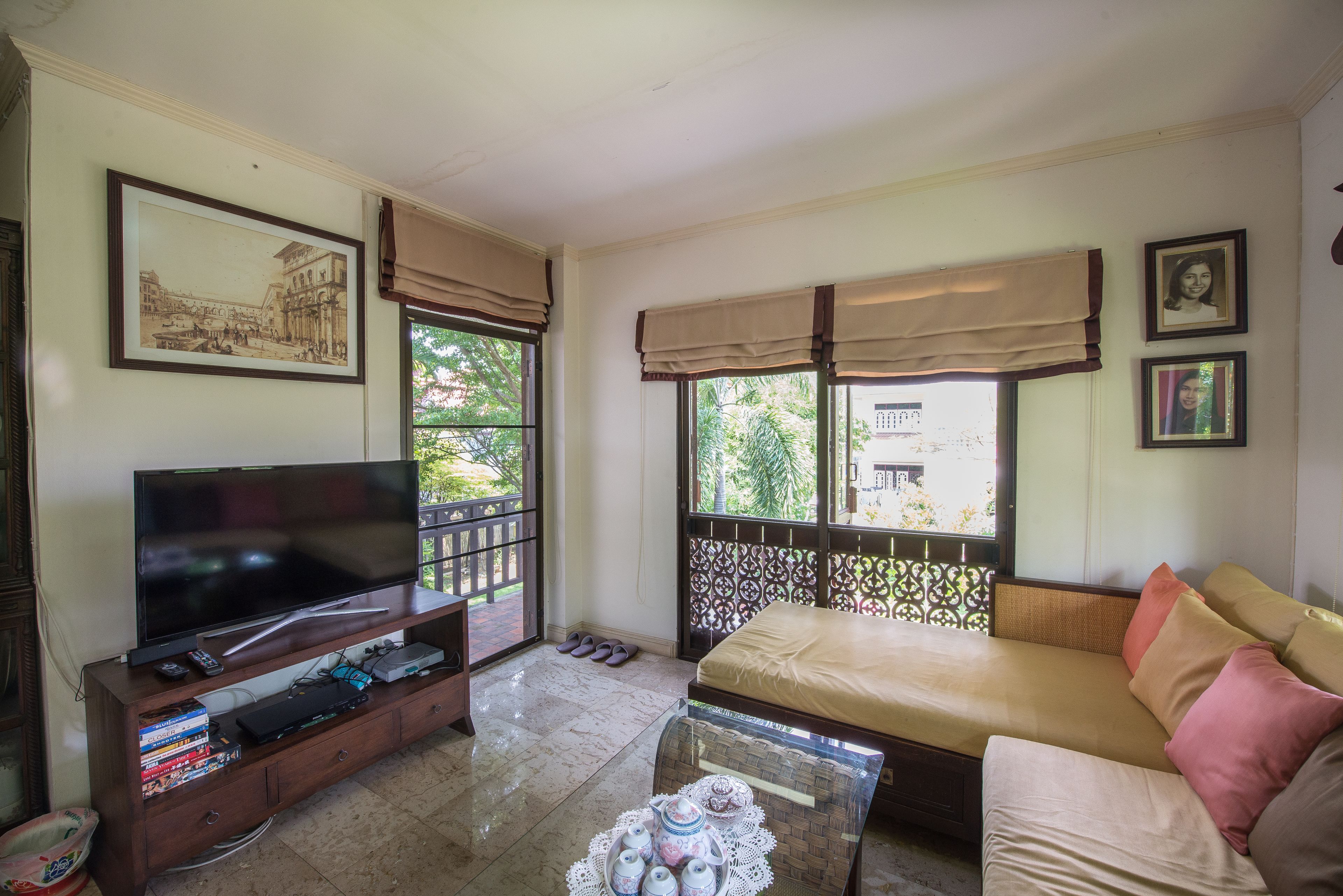 A living room with a TV, sofa, and a coffee table with teapots.
